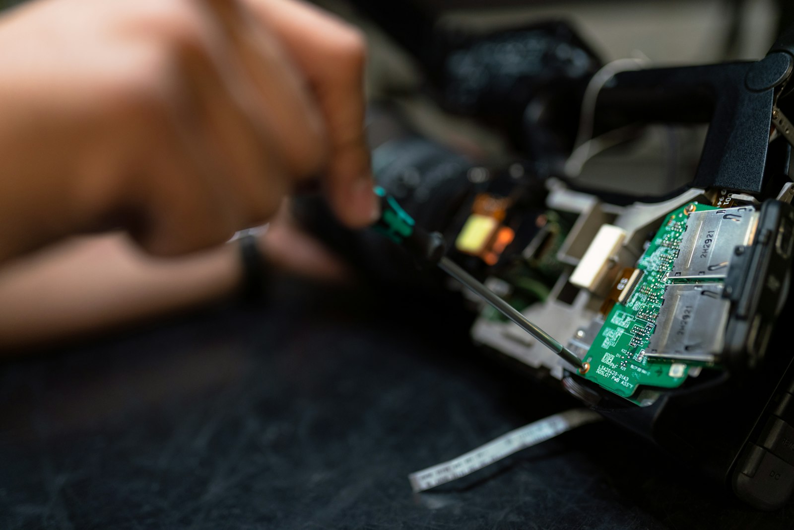 Hands working on an opened device and its board